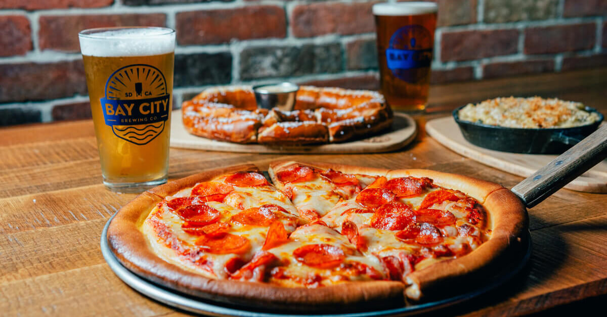 pepperoni pizza next to bay city pint of beer